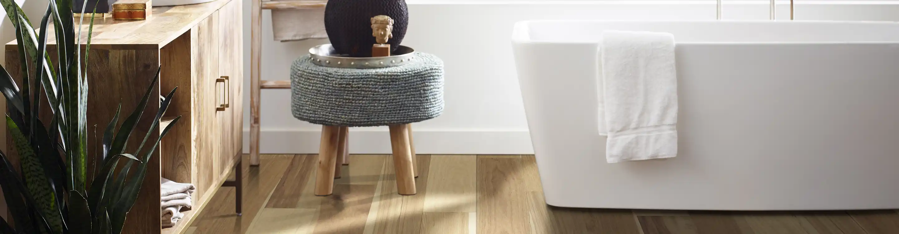 light waterproof wood-look flooring in bathroom with white bathtub